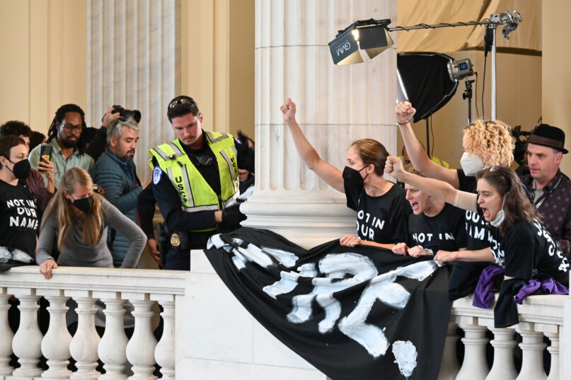Capitol police remove "Ceasefire" banners hung by participants in a protest calling for a ceasefire in Gaza. The demonstrators gathered in U.S. Capitol's Cannon Building rotunda on Wed Oct. 18, 2023. RNS photo by Jack Jenkins