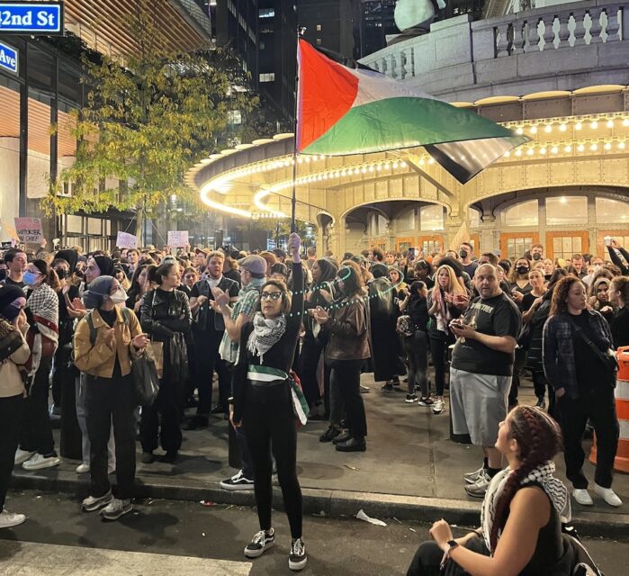 A young woman holds a Palestinian flag aloft as hundreds denied entry to the protest inside Manhattan’s Grand Central Terminal held a second protest along 42nd Street. (RNS photo/Fiona André)