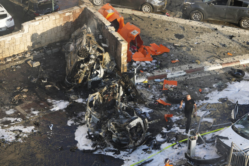 Israeli firefighters extinguish fire after a rocket fired from the Gaza Strip hit a parking lot in Ashkelon, southern Israel, Saturday, Oct. 7, 2023. (AP Photo/Tsafrir Abayov)