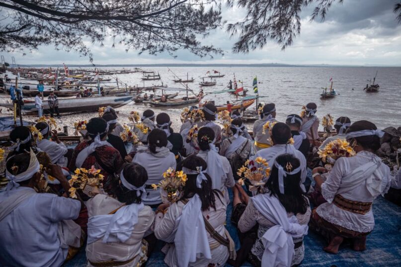 Hindu devotees prepare to scatter ashes of the deceased into the sea as part of Ngaben, a mass cremation ceremony, in Surabaya, Indonesia. (Juni Kriswanto/AFP via Getty Images)