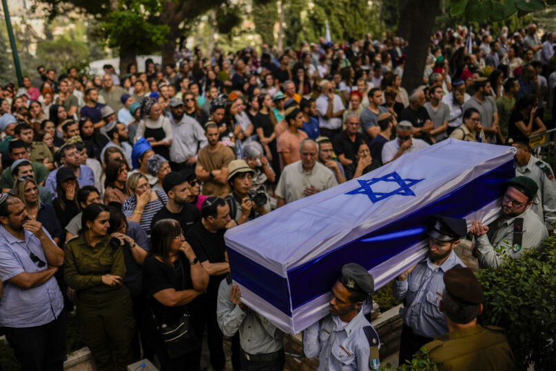 FILE - Israeli soldiers carry the flag-covered coffin of Shilo Rauchberger at the Mount Herzl cemetery in Jerusalem, Thursday, Oct. 12, 2023. In Israel on Oct. 7, rabbis worked around the clock at Shura military base in Israel to identify and count the dead civilians and soldiers gunned down in the Hamas attack. (AP Photo/Francisco Seco, File)