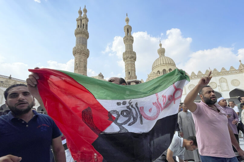 Protesters hold a Palestinian flag reading “Al-Aqsa flood” in Arabic as they leave Friday prayers at Azhar mosque, the Sunni Muslim world’s premier Islamic institution, in Cairo, Oct. 13, 2023. (AP Photo/Amr Nabil)