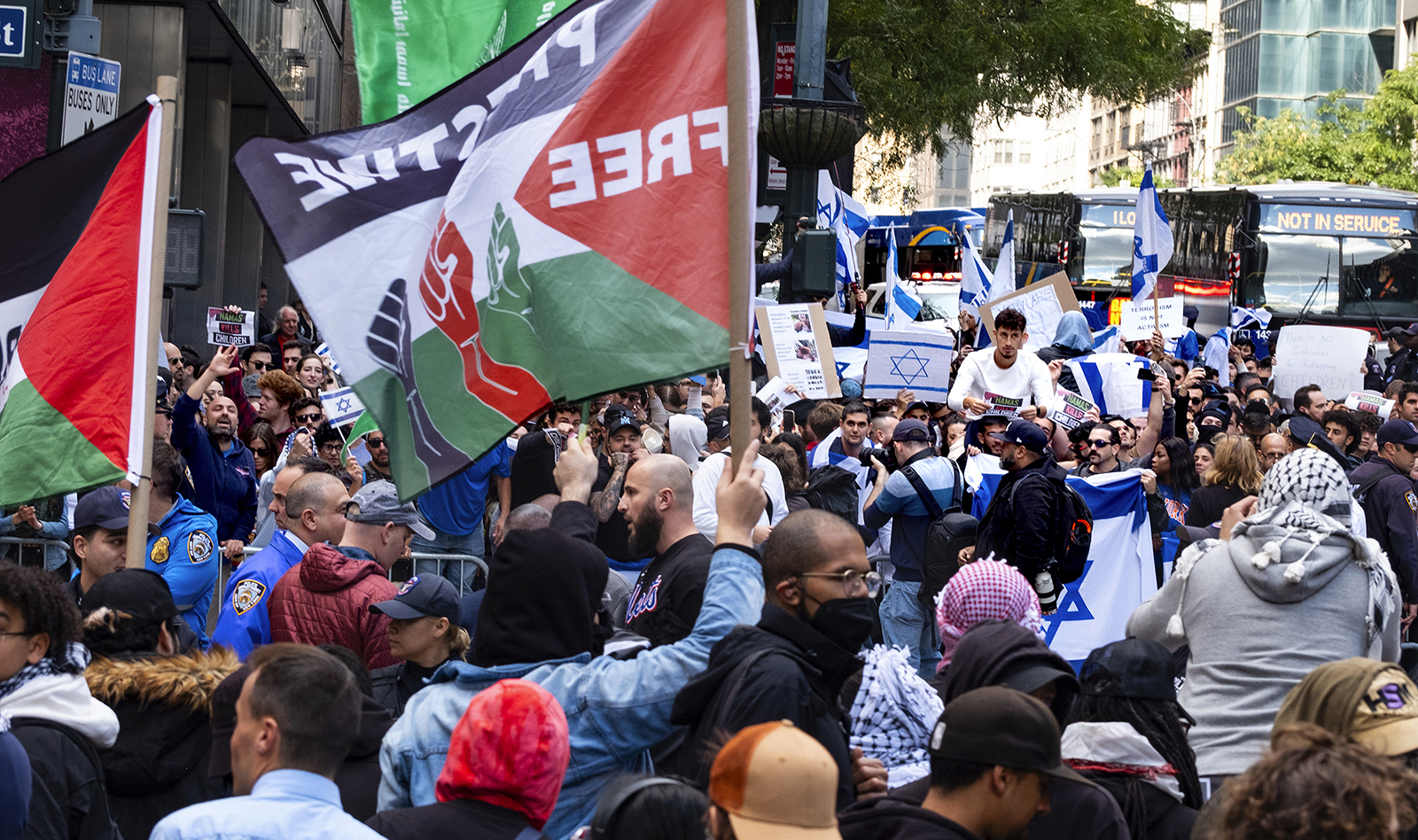 Supporters of Israel, background, and Palestinian supporters, foreground, gather at the Israeli Consulate in New York, Monday, Oct. 9, 2023, in the wake of an attack on Israel by Hamas. (AP Photo/Craig Ruttle)