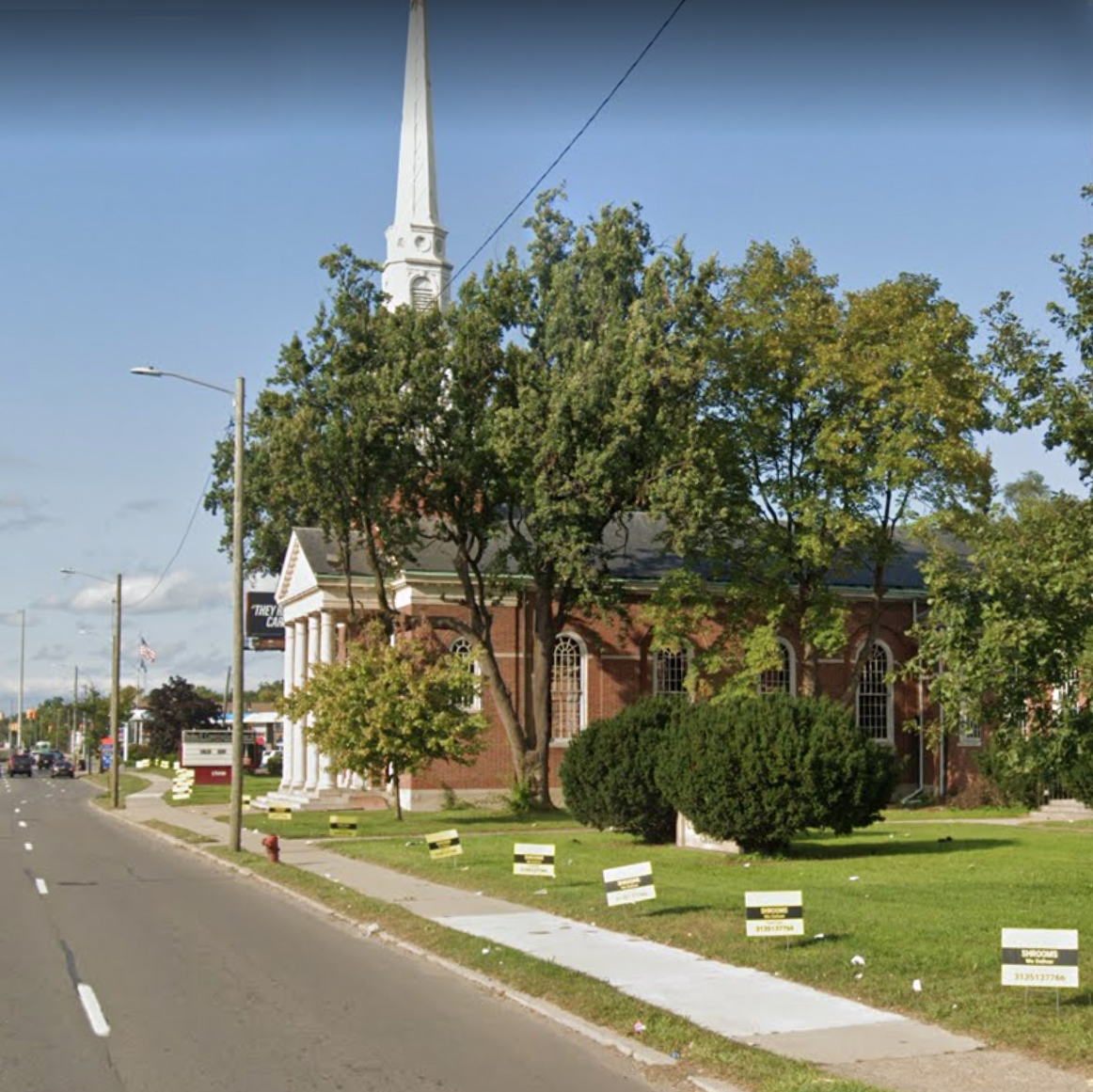 Signs saying "Shrooms: we deliver" for Soul Tribes International line the property of Bushnell Congregational Church in Detroit, Michigan. Image courtesy Google Maps