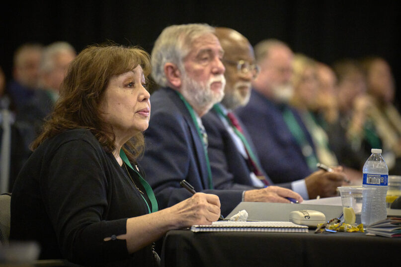 United Methodist Bishop Minerva G. Carcaño takes notes during her church trial on September 19, 2023, in Glenview, Illinois. Beside her are her two counsel, the Rev. Scott Campbell and Judge Jon Gray. Photo by Paul Jeffrey, UM News