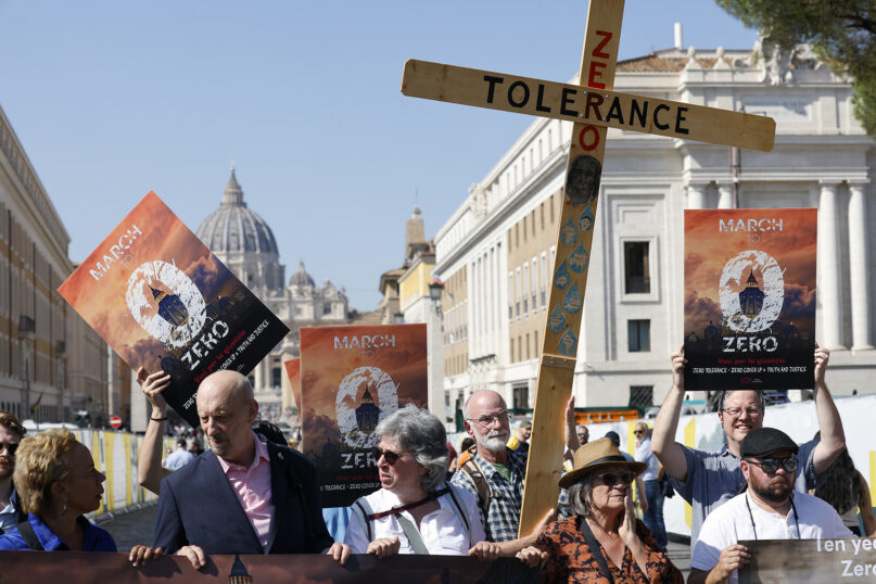 Psychoneurologist Denise Buchanan, from left, psychotherapist Peter Isely, Kazlaw Injury & Trauma Lawyers' support team specialist Leona Huggins, and President of Ending Clergy Abuse Timothy Law, holding a wooden cross, arrive at the Vatican Sept. 27, 2023.  The group ended a zero-tolerance 75-mile pilgrimage initiative, along the Via Francigena, ahead of the synod of bishops starting on Oct. 4 at the Vatican, to protest clergy abuse. (AP Photo/Riccardo De Luca)