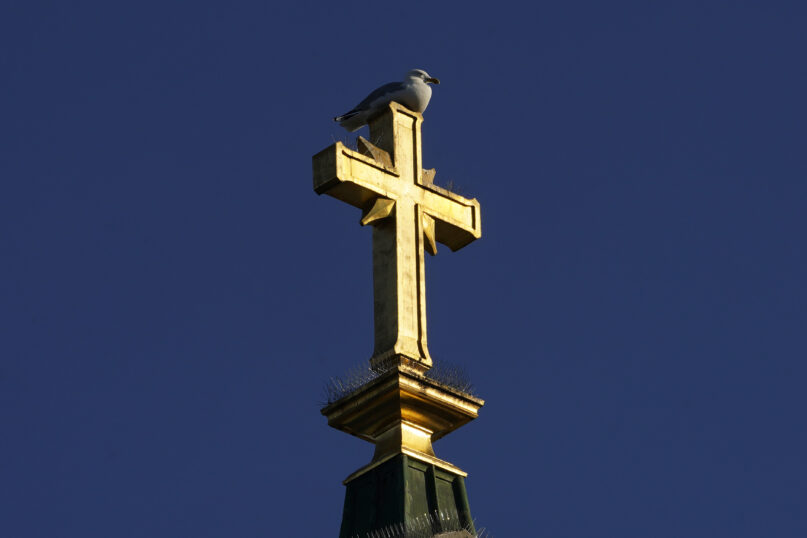 A cross shines in the late-day sun on top of St. Peter's Church, Saturday, May 6, 2023, in Portland, Maine. A change in a statute of limitations laws has allowed several women who claim to be victims of sexual abuse at St. Peter's from 1958 to 1967 to sue the Roman Catholic Diocese of Portland. (AP Photo/Robert F. Bukaty)