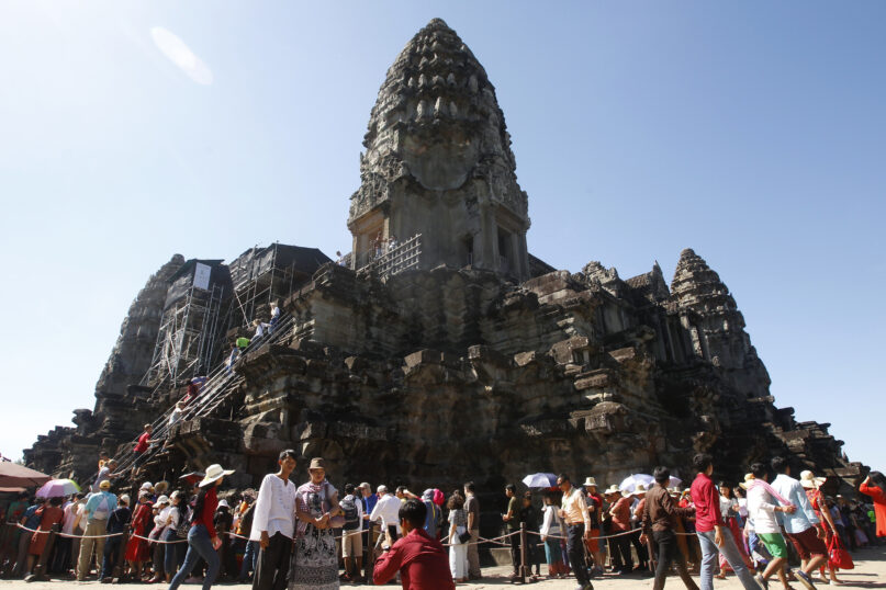 FILE - Tourists line up for stepping up Angkor Wat temple outside Siem Reap, Cambodia, on Dec. 31, 2017. The human rights group Amnesty International in a report released Tuesday Nov. 14, 2023 has strongly criticized the U.N. cultural agency UNESCO and its World Heritage program for failing to challenge the Cambodian government’s ongoing mass evictions at the world famous centuries-old Angkor Wat temple complex. (AP Photo/Heng Sinith, File)