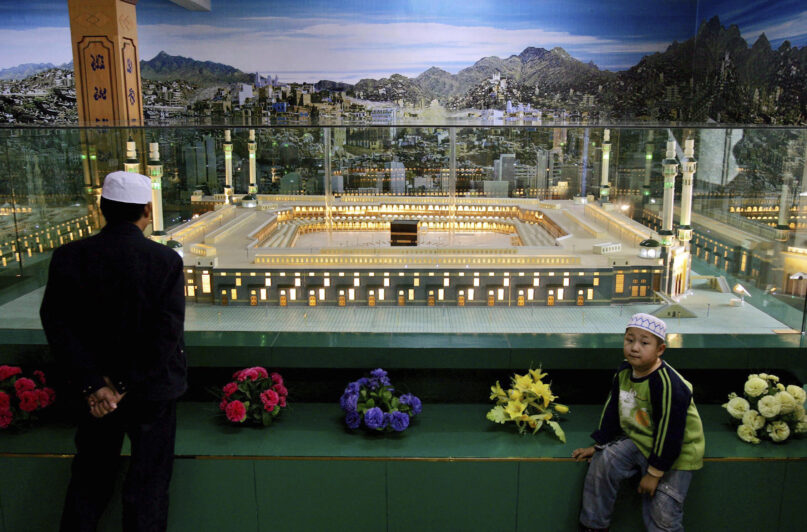 FILE - A Chinese Hui Muslim looks at a scale model of Mecca set up at a mosque in the town of Yichuan during Ramadan in Ningxia province, China, Saturday, Oct. 21, 2006. The Chinese government has expanded its campaign of shuttering mosques to provinces other than Xinjiang, where Beijing has for years been blamed of persecuting Muslim minorities, according to a report released Wednesday by Human Rights Watch. (AP Photo/Elizabeth Dalziel, File)