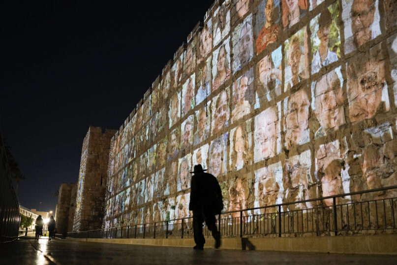 Photographs of Israeli hostages being held by Hamas militants are projected on the walls of Jerusalem's Old City, Nov. 6, 2023. The Islamic militant group killed 1,400 people and kidnapped 240 others in an unprecedented cross-border attack on Oct. 7, triggering a war that has raged for the past month. (AP Photo/Leo Correa)
