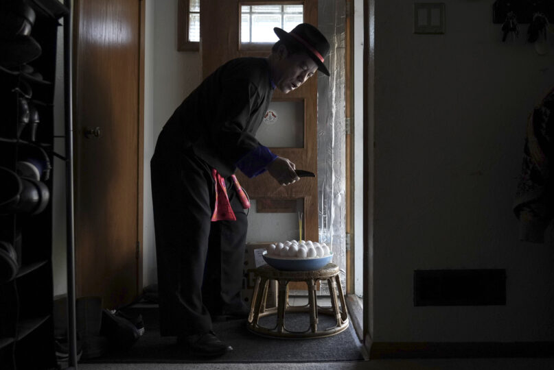 Nhia Neng Vang conducts a soul-calling ritual at his home in St. Paul, Minn. on Saturday, Nov. 18, 2023. In traditional Hmong spirituality, humans are composed of multiple souls, which may become separated over time. The soul-calling ritual returns them for the new year. (AP Photo/Mark Vancleave)
