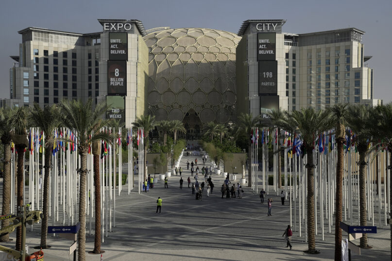 People walk through the venue for the COP28 U.N. Climate Summit, with the Al Wasl Dome in the background, at Expo City, Nov. 29, 2023, in Dubai, United Arab Emirates. (AP Photo/Joshua A. Bickel, File)