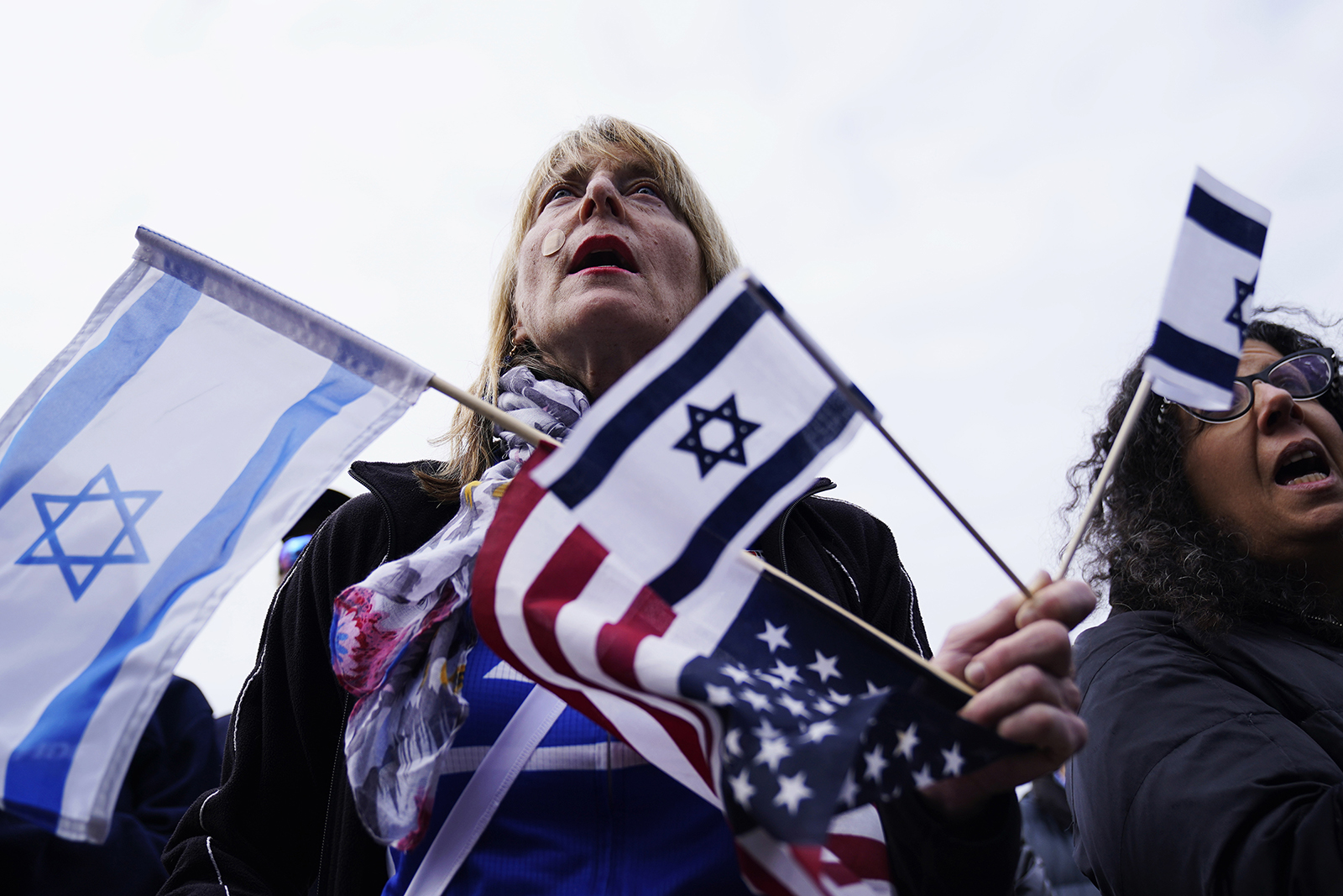 A supporter holds Israeli and American flags at a solidarity event in Glencoe, Ill., Tuesday, Oct. 10, 2023. (AP Photo/Nam Y. Huh, File)