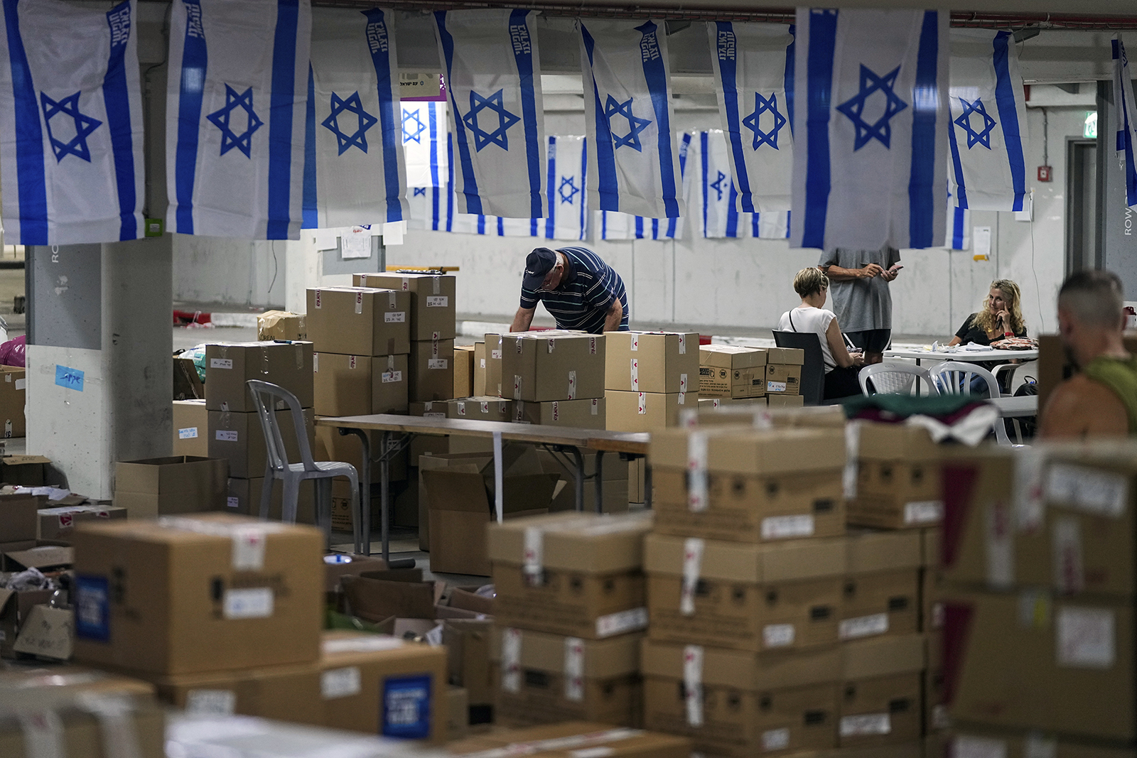 FILE - Volunteers work at a donation center to support Israeli soldiers and the 200,000 Israelis evacuated from their homes in the north and south during the Israel-Hamas war, at the headquarters of the 'Brothers in Arms' aid organization in Tel Aviv, Israel, Israel, Wednesday, Oct. 25, 2023. At a time when world sentiment has begun to sour on Israel's devastating airstrikes in Gaza, the vast majority of Israelis, across the political spectrum, are convinced of the justice of the war. (AP Photo/Ohad Zwigenberg, File)