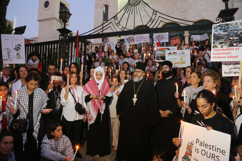 Yasmine Faraa, center left with head covering, participates in a vigil she helped organize outside an Orthodox Christian Church in Amman, Jordanian, Sunday, Oct. 22, 2023. (Photo by Daoud Kuttab)