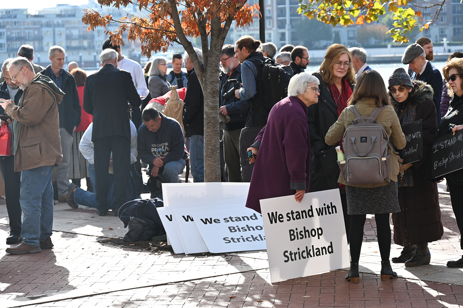 Supporters of Bishop Joseph Strickland gather near the USCCB meeting in Baltimore, Wednesday, Nov. 15, 2023. Strickland, rear left, prays over kneeling individuals. (RNS photo/Jack Jenkins)