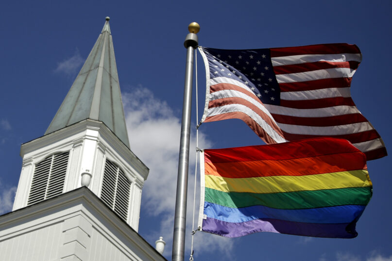 FILE - A gay pride rainbow flag flies along with the U.S. flag in front of the Asbury United Methodist Church in Prairie Village, Kan., on April 19, 2019. A quarter of U.S. congregations in the United Methodist Church received permission to leave the denomination during a five-year window, which closed in December 2023, that authorized departures for congregations over disputes involving the church's LGBTQ-related policies. (AP Photo/Charlie Riedel, File)