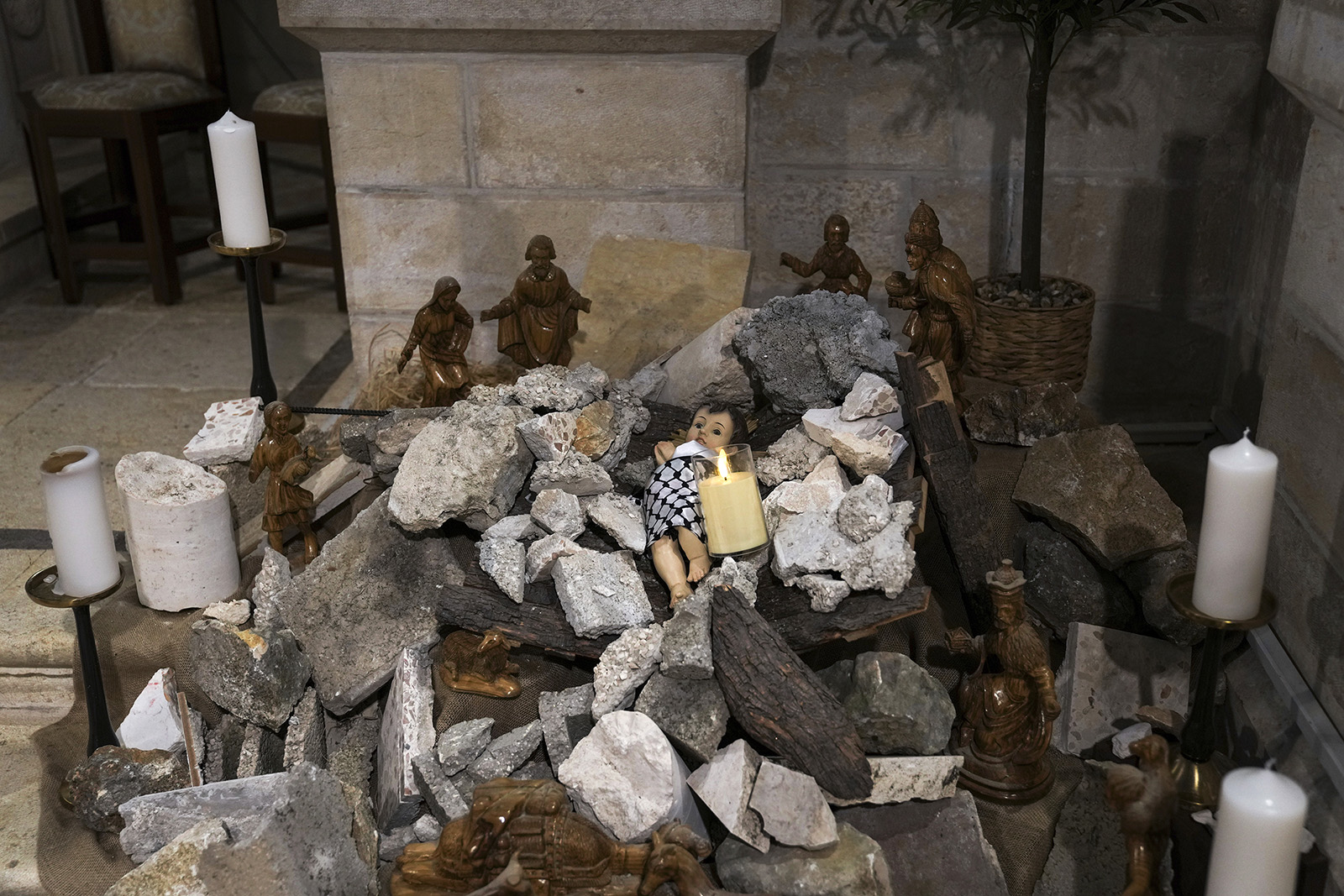 An installation of a scene of the Nativity of Christ with a figure symbolizing baby Jesus lying amid the rubble, in reference to Gaza, inside the Evangelical Lutheran Christmas Church in the West Bank town of Bethlehem, Sunday, Dec. 10, 2023. World-famous Christmas celebrations in Bethlehem have been put on hold due to the ongoing Israel-Hamas war. (AP Photo/Mahmoud Illean)