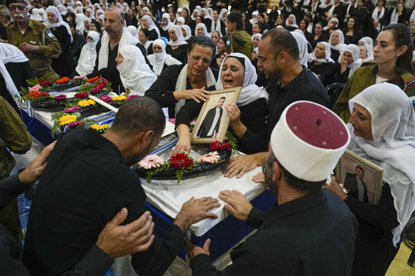 Mourners gather around the flag draped coffin of Druze Israeli Lieutenant Colonel Salman Habaka in the village of Yanuh Jat, northern Israel, Friday, Nov. 3, 2023. Habaka was killed during a ground operation in the Gaza Strip. (AP Photo/Ariel Schalit)