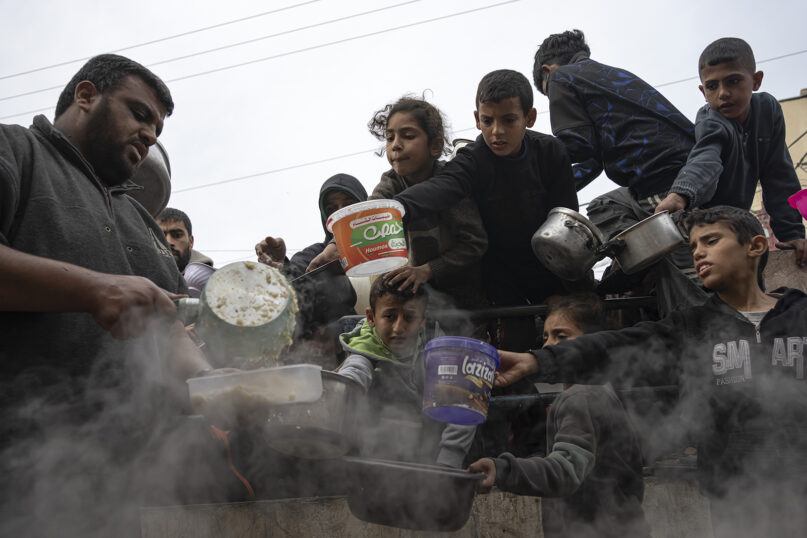 Palestinians line up for a free meal in Rafah, Gaza Strip, Dec. 21, 2023. International aid agencies say Gaza is suffering from shortages of food, medicine and other basic supplies as a result of the  war between Israel and Hamas. (AP Photo/Fatima Shbair)