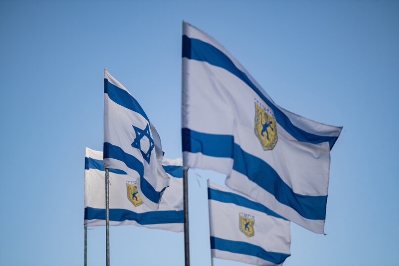 Flags of Israel and the city of Jerusalem. (Photo by Levi Meir Clancy/Unsplash/Creative Commons)