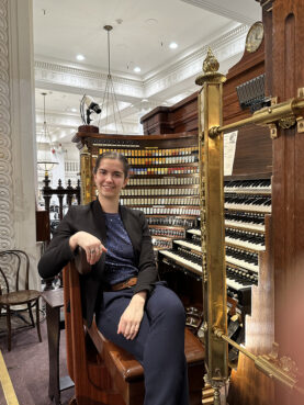 Emily Amos poses with the Wanamaker Organ in Philadelphia in 2023. (Photo by Dawn Amos)