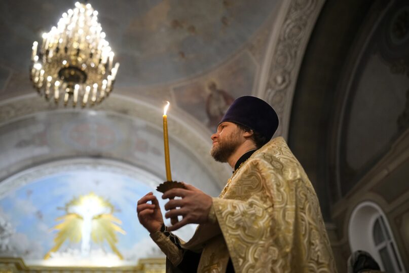 A Russian Orthodox Church priest makes the sign of the cross during an Orthodox Christmas service at the Church of the Holy Martyr Tatiana near the Kremlin Wall in Moscow, Russia, late Saturday, Jan. 6, 2024. (AP Photo/Alexander Zemlianichenko)