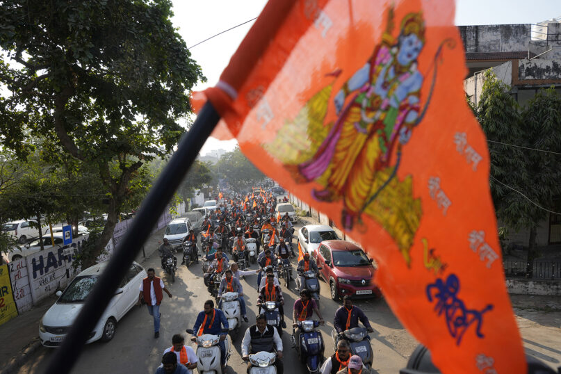 A saffron flag with an image of Hindu deity Ram is seen in the foreground as supporters of India's ruling Bharatiya Janata Party (BJP) celebrate the upcoming opening of a grand Ram temple in Ayodhya, at a two-wheeler rally in Ahmedabad, India, Friday, Jan. 19, 2024. The Ayodhya temple's opening will fulfill a decadeslong Hindu nationalist pledge that is expected to resonate with voters during the upcoming national election. (AP Photo/Ajit Solanki)