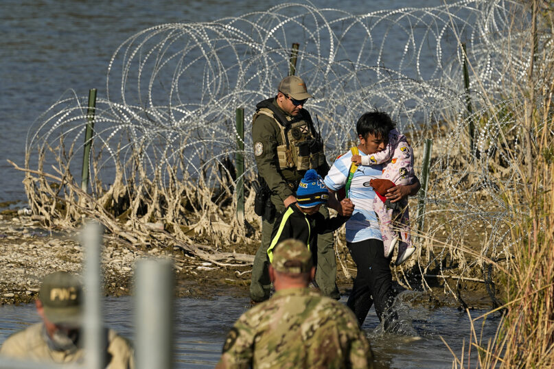 Migrants are taken into custody by officials at the Texas-Mexico border, Wednesday, Jan. 3, 2024, in Eagle Pass, Texas. (AP Photo/Eric Gay)