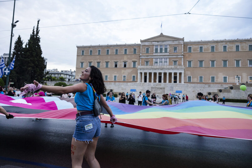 Participants carry flags in front of the Greek parliament building during the annual Pride parade, in Athens, Saturday, June 10, 2023. Greece’s center-right government is speeding up its timetable to legalize same-sex marriage despite growing opposition from the powerful Orthodox Church. Government officials said on Wednesday, Jan. 24, 2024, that draft legislation would be put to a vote by mid-February. (AP Photo/Yorgos Karahalis)