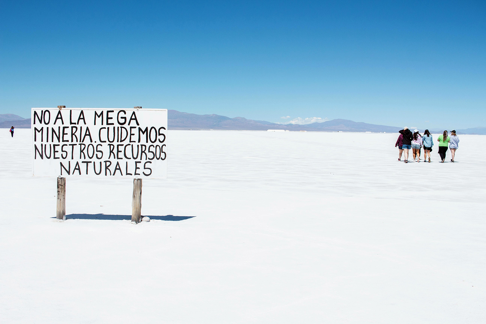 Tourists visit Salinas Grandes salt flats in Jujuy province, Argentina. A sign in Spanish reads "No to mega mining. Let's take care of our natural resources." (Photo by Maggy Idrobo López/Pexels/Creative Commons)
