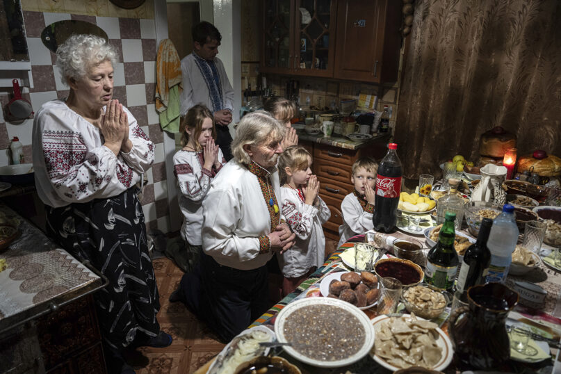 The Zelenchuk family prays before a Christmas dinner in Kryvorivnia village, Ukraine, Dec. 24, 2023. (AP Photo/Evgeniy Maloletka)
