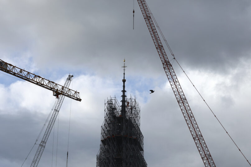 Scaffolding is being removed around the spire of Notre Dame de Paris cathedral, showing the rooster and the cross, Monday, Feb. 12, 2024 in Paris. Notre Dame is expected to reopen in Dec. 2024 following the devastating fire in April 2019. (AP Photo/Aurelien Morissard)