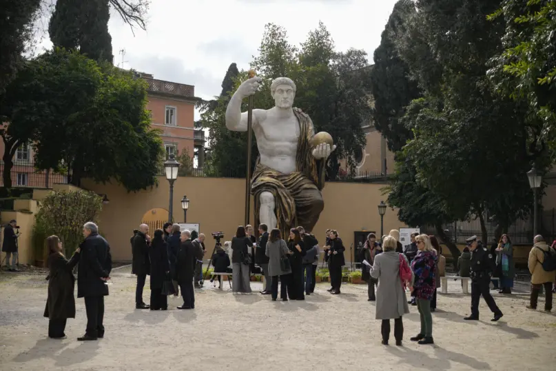 Visitors admire a massive, 13-meter (yard) replica of the statue Roman Emperor Constantine commissioned for himself after 312 AD that was built using 3D technology from scans of the nine giant original marble body parts that remain, as it was unveiled in Rome, Tuesday, Feb. 6, 2024. (AP Photo/Andrew Medichini)