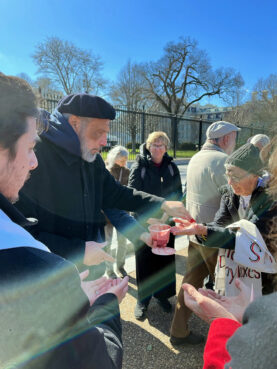 The Rev. Graylan Hagler marks peoples' hands with a red liquid during a cease-fire protest near the White House in Washington, Wednesday, Feb. 14, 2024. (RNS photo/Aleja Hertzler-McCain)