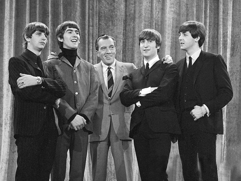 The Beatles with Ed Sullivan from their first appearance on Sullivan's U.S. variety television program in February 1964. From left: Ringo Starr, George Harrison, Ed Sullivan, John Lennon and Paul McCartney. (Photo by CBS Television/Wikipedia)