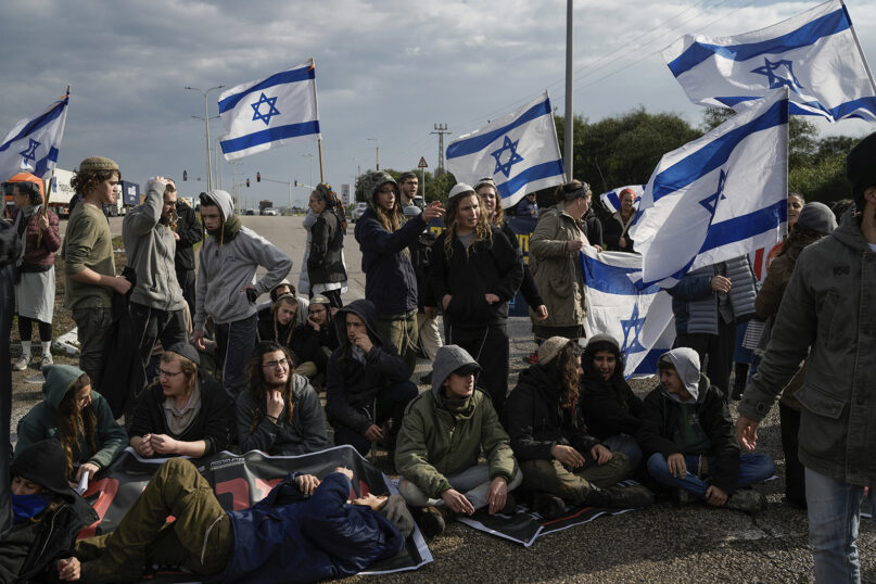 Israeli activists block the exit of Ashdod port to stop trucks they claim are carrying humanitarian aid destined for the Gaza Strip, in Ashdod, Israel, Thursday, Feb. 1, 2024. The activists say no aid should enter the territory until Israeli hostages held captive by the Hamas militant group are released. (AP Photo/Leo Correa)