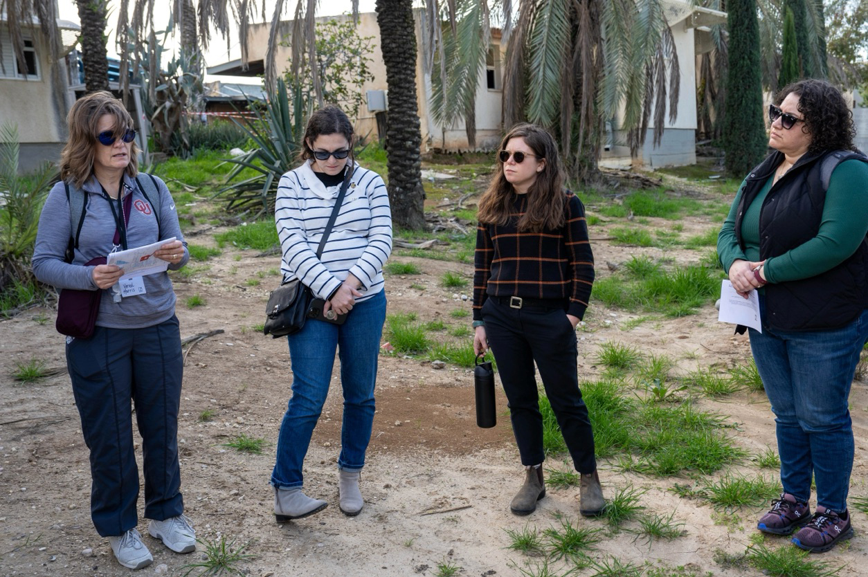 Rabbi Liz P.G. Hirsch, middle right, joins other mission participants to recite the Mourner’s Kaddish at the edge of Kfar Azza, during a recent mission trip to Israel. (Photo by Elana Goodridge)