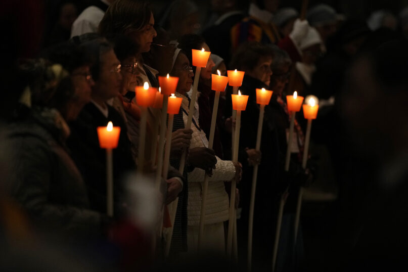 People hold candles during a Mass for religious orders with Pope Francis, in St. Peter’s Basilica at the Vatican, Feb. 2, 2024. (AP Photo/Andrew Medichini)