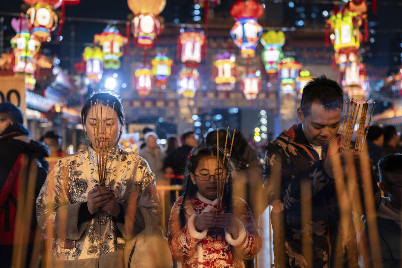 Worshippers pray as they burn their joss sticks at a temple to welcome in the Lunar New Year of the Dragon in Hong Kong, Feb. 9, 2024. (AP Photo/Louise Delmotte)
