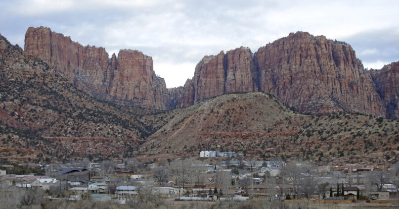 FILE - Hildale, Utah, is pictured sitting at the base of Red Rock Cliff mountains, with its sister city, Colorado City, Ariz., in the foreground on Dec. 16, 2014.  On Tuesday, March 19, 2024, a businessman pleaded guilty to conspiring with the leader of an offshoot polygamous sect in the Colorado City-Hildale area to transport underage girls across state lines for sexual activity. The guilty plea by 53-year-old Moroni Johnson marked the first man to be convicted in what authorities say was a scheme to orchestrate sexual acts involving children. (AP Photo/Rick Bowmer, File)