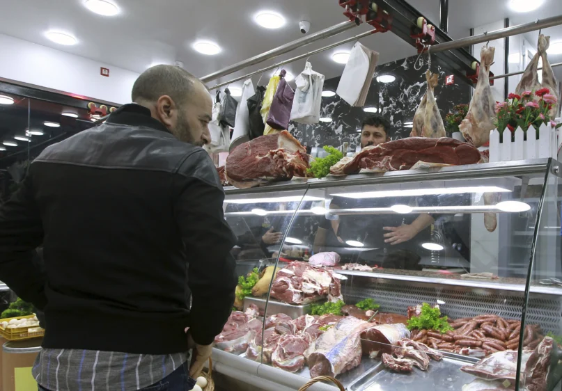 People shop for beef at a butchery in Algiers, Algeria, Sunday, Feb. 18. 2024. (AP Photo/Fateh Guidoum)