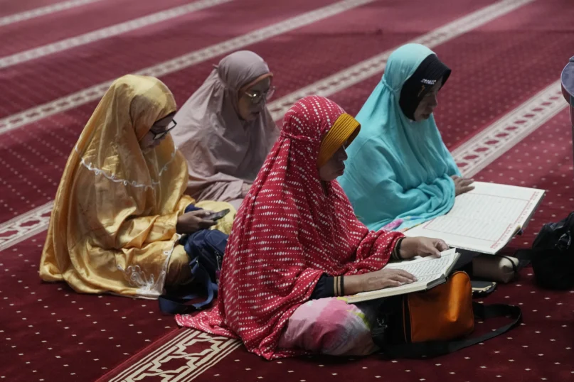 Muslim women read the Quran while waiting for the time to break their fast during the first day of Ramadan at the Istiqlal Mosque in Jakarta, Indonesia, Tuesday, March 12, 2024. (AP Photo/Achmad Ibrahim)