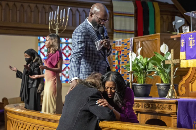 Rev. William H. Lamar IV, top, and Rev. Colette Thomas, right, pray with a parishioner during Palm Sunday services at the Metropolitan AME Church in Washington, Sunday, March 24, 2024. (AP Photo/Amanda Andrade-Rhoades)
