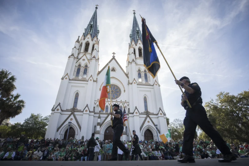 Participants carry flags past the Cathedral Basilica of St. John the Baptist while marching in the St. Patrick’s Day parade, March 17, 2023, in historic downtown Savannah, Ga. (AP Photo/Stephen B. Morton)