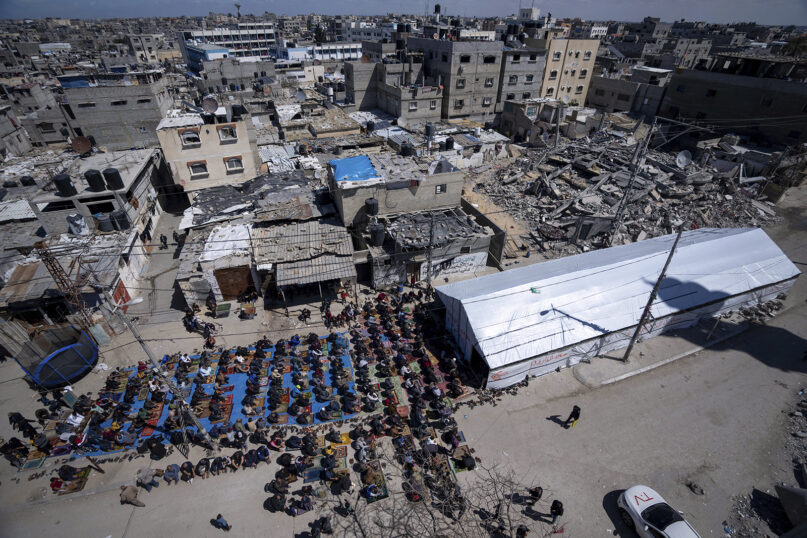Palestinians perform the first Friday prayers of the Muslim holy month of Ramadan near the ruins of a mosque destroyed by Israeli airstrikes in Rafah, Gaza Strip, March 15, 2024. (AP Photo/Fatima Shbair)