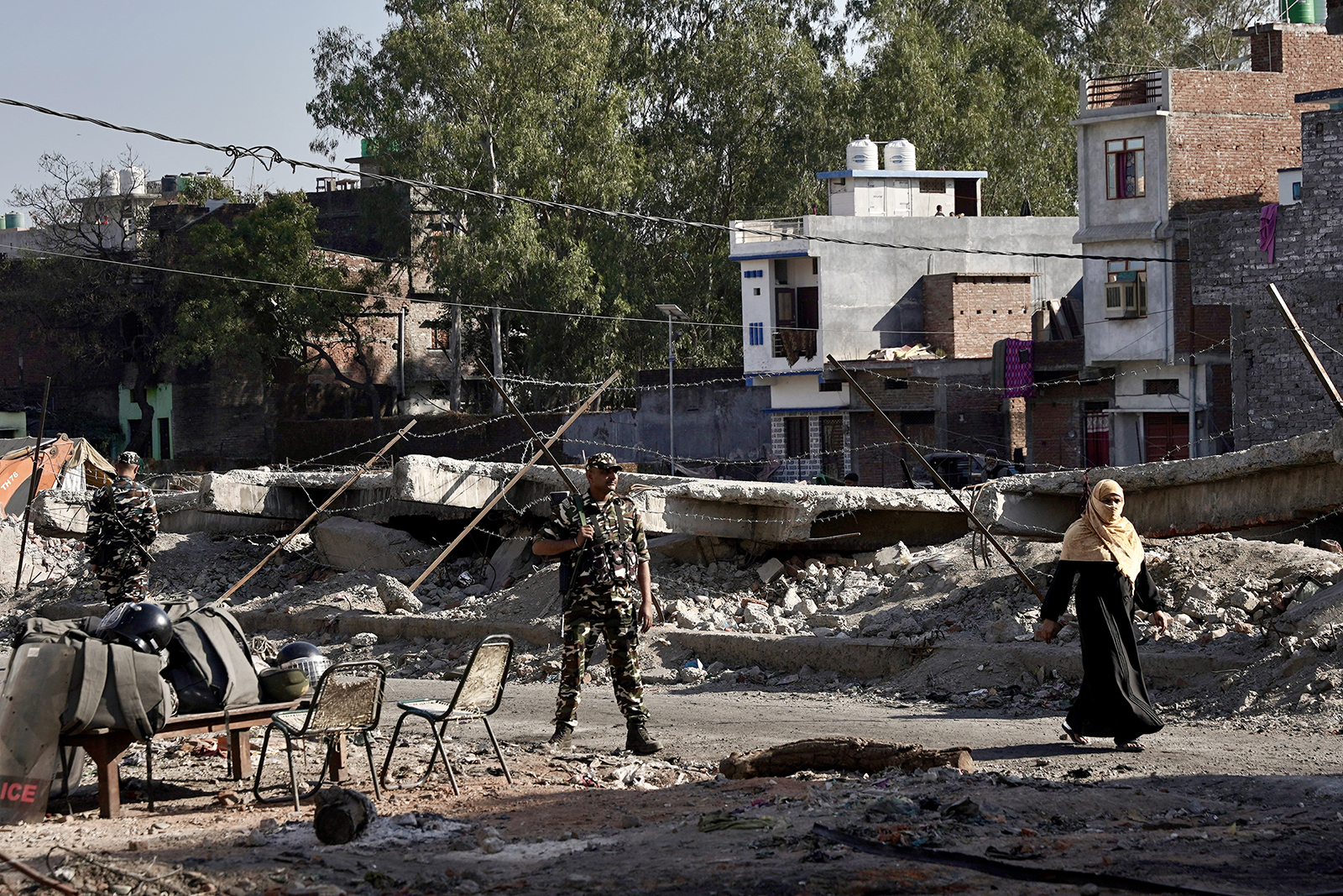 Um pedestre, à direita, passa pelo local vigiado de uma antiga mesquita e sua madrassa em Haldwani, Índia, em 23 de fevereiro de 2024. A agitação eclodiu após a destruição da casa de culto muçulmana.  (Foto de Bhat Burhan)