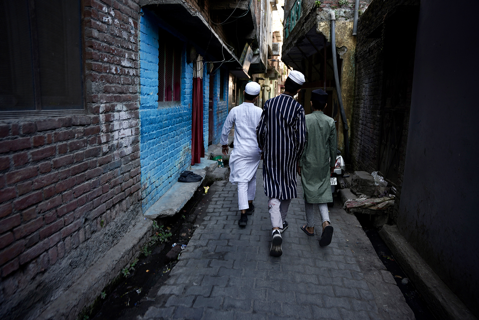 Jovens muçulmanos passam pelo bairro de Banbhoolpura em Haldwani, Índia, em 23 de fevereiro de 2024. (Foto de Bhat Burhan)