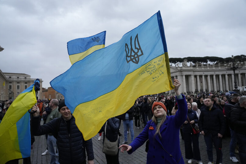 People wave Ukrainian flags before Pope Francis delivers the Angelus noon prayer from the window of his studio overlooking St. Peter’s Square, at the Vatican, March 10, 2024. (AP Photo/Alessandra Tarantino)