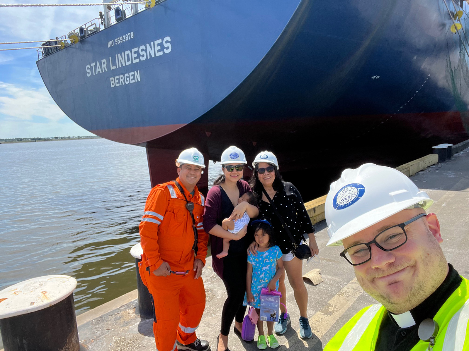 The Rev. Joshua Messick, right, executive director of the Baltimore International Seafarers’ Center in Maryland, takes a selfie with a seafarer and his family. (Photo courtesy Joshua Messick)